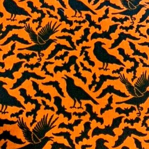 Op de afbeelding: Een zwarte en oranje stof met een herhalend patroon van vleermuizen en raven. De stof is perfect voor Halloween-knutselwerk en decoraties.