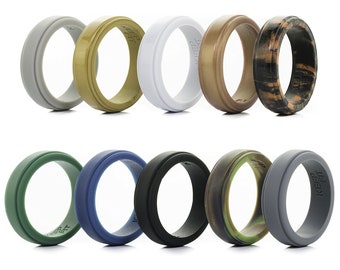 May include: A collection of ten silicone rings in various colors, including gray, olive green, white, and camouflage patterns. Each ring has a grooved design and the text "KEEP FIT" is visible on some rings.