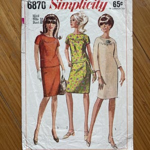 Peut inclure: Patron de couture Simplicity vintage 6870 avec trois modèles de robes. La couverture présente des illustrations de robes orange, à fleurs vertes et beige. Le texte comprend "Simplicity" et "Miss Size 12 Bust 32".