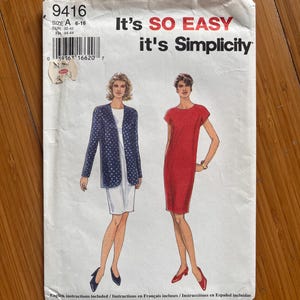 Könnte beinhalten: Ein Simplicity Schnittmusterumschlag 9416, Größe A 6-16, mit Abbildungen eines weißen Kleides mit einer marineblauen, gepunkteten Jacke und eines einfarbigen roten Kleides. Der Text lautet It's SO EASY it's Simplicity, mit Anleitungen in Englisch, Französisch und Spanisch.