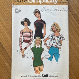 May include: Simplicity sewing pattern number 5078 for knit fabrics. The pattern includes four views: a black sleeveless top, a striped long-sleeved top, a green sleeveless top, and a floral print top with short sleeves. The pattern is designed for size 12, bust 34, and is for misses.