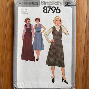 Può includere: Una busta per cartamodello Simplicity 8796 per le taglie 22 1/2 e 24 1/2. La copertina presenta illustrazioni di tre varianti di un abito senza maniche indossato sopra top a maniche lunghe, incluso un abito a quadri al ginocchio.