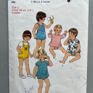 May include: A sewing pattern for toddler clothing. The pattern includes three different outfits: a blue and white gingham romper, a pink and white dress with puffed sleeves, and a blue and white floral print romper. The pattern is labelled "1145" and "Style".
