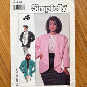 May include: Simplicity sewing pattern number 8176, size SM, for a Jiffy jacket. The pattern shows three different versions of the jacket, one in pink, one in black, and one in teal. The pattern is for a women's jacket.