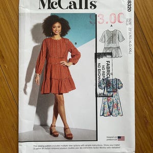 Könnte beinhalten: Ein Schnittmuster für ein Kleid mit mehreren Ansichtsoptionen. Das Schnittmuster ist für die Größen groß, extra groß und extra extra groß. Das Schnittmuster ist in den USA gedruckt.