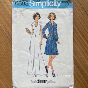 Peut inclure: Patron de couture Simplicity vintage numéro 6883 pour une robe. Le patron est pour une longue robe blanche avec un col et une courte robe bleue à fleurs avec un col. Le patron est intitulé "Look Slimmer" et est vendu 1,50 $.