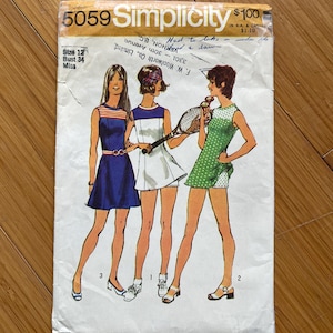 Peut inclure: Un patron de couture vintage Simplicity pour une robe de tennis. Le patron est pour une taille 12, un tour de poitrine de 86 cm, et est pour une jeune femme. Le patron montre trois femmes portant différentes versions de la robe. La robe est une robe courte et sans manches avec un col rond et une jupe plissée. Le patron est en bon état, avec quelques signes d'usure.