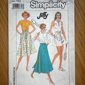 May include: Simplicity pattern 9109 Jiffy, size MD, for a skirt with a wrap-around waist. The pattern shows three different styles of skirts: a white skirt with a floral print, a blue skirt, and a white skirt with a tennis-inspired design.