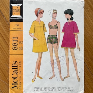 May include: Vintage McCall's sewing pattern for a women's bathing suit and beach coat. The pattern is for sizes 18 and bust 38. The pattern is printed on white paper with a yellow border and features illustrations of three women wearing the different garments.
