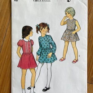 May include: A vintage sewing pattern for children's dresses. The pattern is for size 4 and includes three different styles. The pattern is called "Style" and has the number 4686 on it.