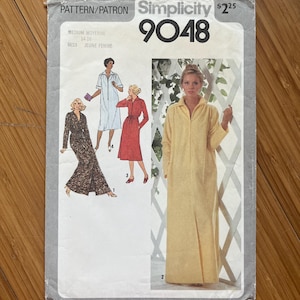 May include: Simplicity sewing pattern number 9048 for a long dress with a collar and a front opening. The pattern is for sizes 14-16 and is for misses. The pattern shows three different styles of the dress, one with a long sleeve, one with a short sleeve, and one with a sleeveless style.