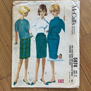 Puede incluir: Patrón de costura impreso McCall's vintage con ilustraciones de tres conjuntos para preadolescentes: falda y blusa en tres versiones. El patrón incluye la talla 85, contorno de busto 28. La palabra "EASY" está impresa.