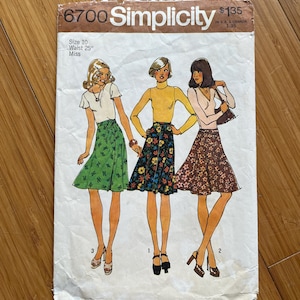 Puede incluir: Patrón de costura vintage Simplicity número 6700 para una falda. El patrón es para la talla 10 con una cintura de 63,5 cm. El patrón muestra tres estilos de faldas diferentes, una con estampado floral verde, otra con estampado floral multicolor y otra con estampado floral marrón.
