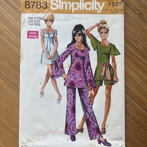 Puede incluir: Patrón de costura vintage Simplicity número 8783 para jóvenes junior y adolescentes. El patrón incluye tres atuendos diferentes: un pantalón de estampado floral morado, un vestido verde con una faja y un vestido azul con un cuello blanco. El patrón es para las tallas 9/10 con una medida de busto de 78 cm.