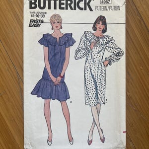 May include: Vintage sewing pattern for a dress, Butterick pattern number 4967, size 8-10-12, with a ruffled collar and long sleeves. The pattern is for a dress with a polka dot print and a solid blue dress.