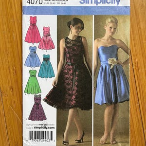 Può includere: Modello di cucito Simplicity numero 4070 per le taglie 6, 8, 10, 12 e 14. Il modello include istruzioni per realizzare cinque diversi abiti. Gli abiti sono mostrati su tre modelli. Il primo abito è un abito rosa con una gonna ampia. Il secondo abito è un abito azzurro con una gonna ampia. Il terzo abito è un abito nero con un corpetto in pizzo e una gonna ampia. Il quarto abito è un abito verde con una gonna ampia. Il quinto abito è un abito viola con una gonna ampia.