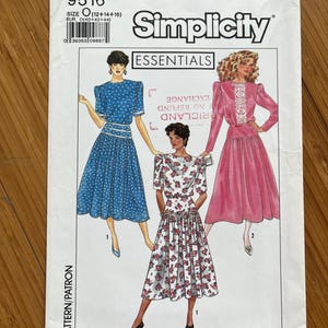 May include: Simplicity Essentials sewing pattern number 9516 for sizes 12-14-16. The pattern includes three different dress styles: a blue polka dot dress, a white floral dress, and a pink dress with white lace trim.