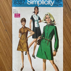 May include: Simplicity sewing pattern number 8387 for a dress. The pattern is for a miss, size 14, bust 36. The pattern shows three different styles of dresses, all with a collar and button closure. The dresses are in brown, green, and black and white.
