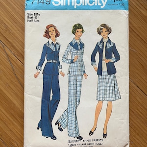 May include: Vintage Simplicity sewing pattern number 7149 for a half-size women's outfit. The pattern includes three different looks: a blue pantsuit, a plaid pantsuit, and a plaid skirt and jacket. The pattern is for a bust size of 104 cm.