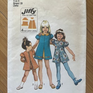 Op de afbeelding: Een Simplicity-naaipatroon voor een kinderjurk. Het patroonnummer is 9895 en de prijs is 85 cent. Het patroon is voor een jurk van maat 4 met een borstomvang van 23 inch. Het patroon bevat vier hoofdonderdelen en is gemakkelijk te naaien.