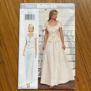 Op de afbeelding: Een Butterick naaipatroon-envelop met een formeel jurk-ontwerp. De envelop toont een tekening en een foto van de jurk, samen met het patroonnummer, de maat en merkinformatie. De jurk is een tweedelige formele jurk.