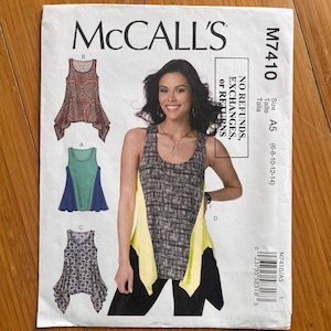 May include: A McCall's M7410 sewing pattern envelope for a sleeveless tank top with a handkerchief hem. The front displays three variations of the top in different patterns and colours, alongside a photograph of the garment in a black and yellow print.