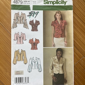 May include: Simplicity sewing pattern number 4879 for a women's blouse with different sleeve options. The pattern includes instructions for making a blouse with short sleeves, long sleeves, and bell sleeves. The pattern is designed by Karen Z. and is available in sizes 10-12, 32-38, and 34-40.