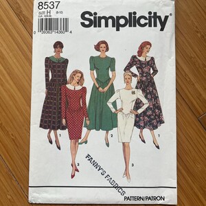 May include: Simplicity sewing pattern 8537 showing illustrations of five dress designs. The pattern includes the text "FANNY'S FABRICS" and "PATTERN/PATRON". The size is H (8-10).