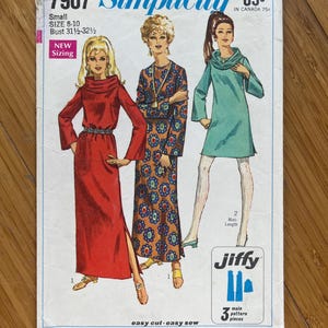 May include: Vintage Simplicity sewing pattern number 7907 for a dress with a cowl neck and long sleeves. The pattern is for sizes 8-10 and has a bust measurement of 31 1/2 to 32 1/2 inches. The pattern is labeled "easy cut - easy sew" and "Jiffy" with 3 main pattern pieces. The pattern cover features three women wearing different versions of the dress.