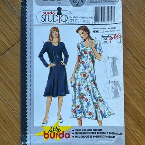 May include: Burda Style Studio sewing pattern number 3274 for a dress. The pattern includes instructions for three different styles of dresses. The pattern is for sizes 10-54. The pattern is for a dress with a floral print, a solid blue dress, and a dress with a white and grey print.