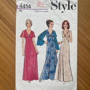 以下が含まれることがあります： 3つの異なるスタイルのロングドレス用のヴィンテージ裁縫パターン。パターンはバスト86cmのサイズ12用です。パターンは「スタイル」と呼ばれ、4414という番号が印刷されています。