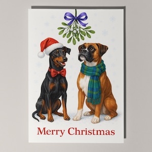 Puede incluir: Tarjeta de Navidad con dos perros. Un perro negro con gorro de Papá Noel y pajarita roja. El otro, un Boxer marrón, lleva una bufanda verde y azul. El texto "Merry Christmas" está en la parte inferior.