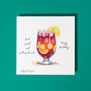 Handgemaakte robijnrode sangriacocktail: rijk, soepel en vol karakter.  Fijne verjaardagskaart Premium-wenskaart en envelop