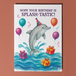 May include: A birthday card with a watercolor illustration of a gray dolphin wearing a party hat, leaping from blue water. Colorful balloons and wrapped gifts surround the dolphin. The text reads, "HOPE YOUR BIRTHDAY IS SPLASH-TASTIC!"