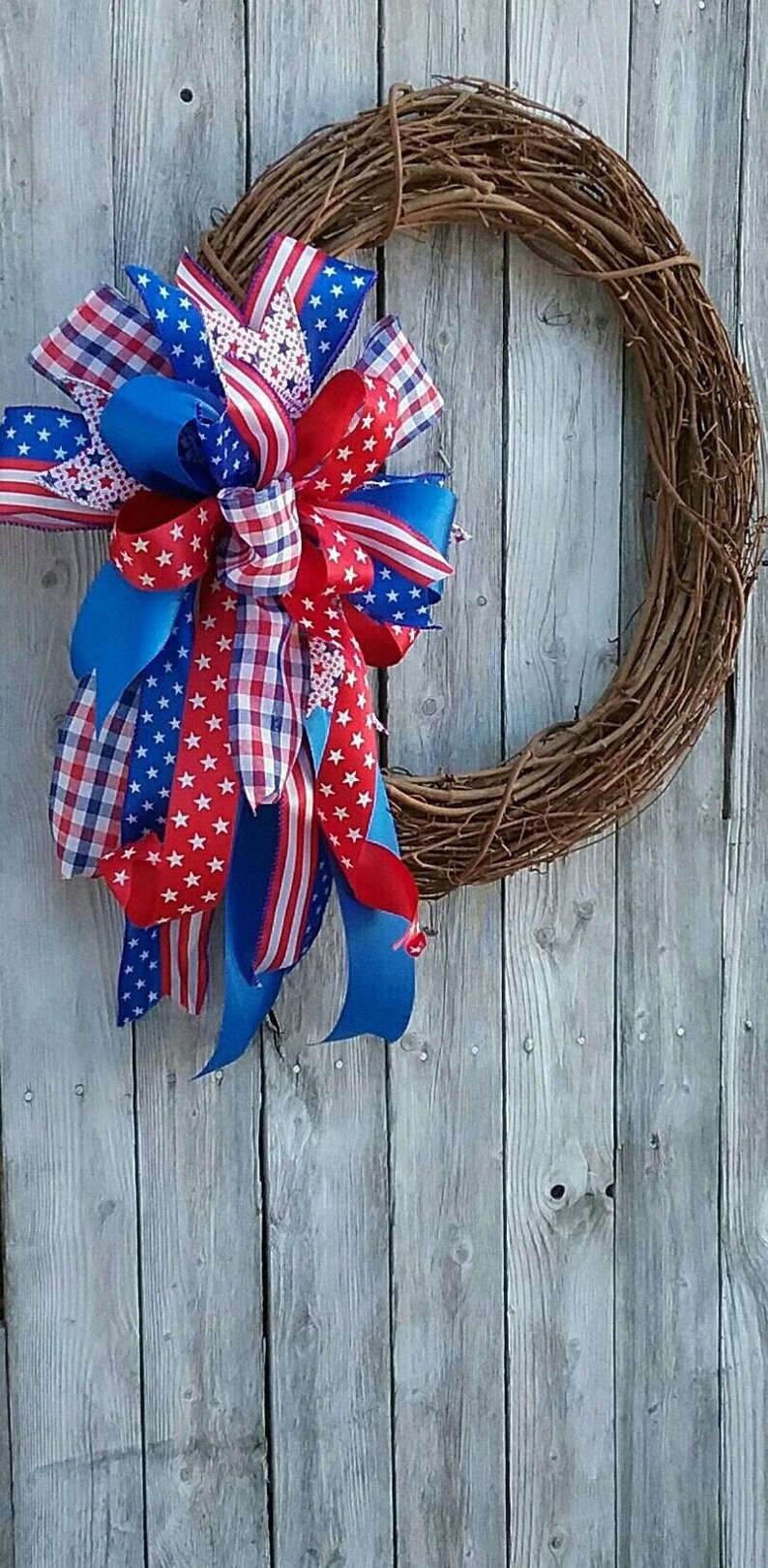 May include: A red, white, and blue ribbon wreath with a grapevine base. The ribbon is patterned with stars and checks.
