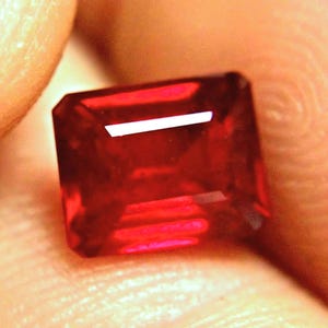 May include: A deep red gemstone with a rectangular shape and a polished finish.