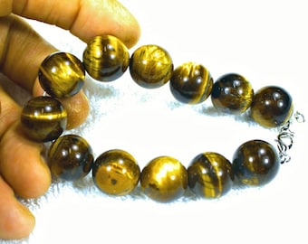 May include: A brown and gold tiger's eye beaded bracelet with a silver clasp.