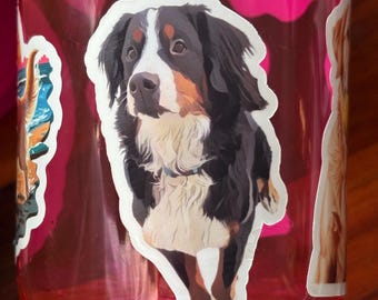 May include: A sticker of a Bernese Mountain Dog on a pink water bottle. The dog is brown, black, and white with a white chest and a black nose.