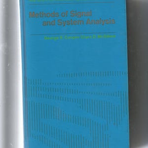 May include: A teal-colored book titled "Methods of Signal and System Analysis" by George R. Cooper and Clare D. McGillem. The title and author's names are in gold lettering. The book has a pattern of vertical lines.