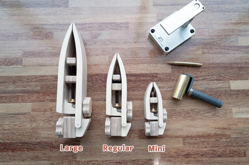 May include: Three wooden leather working tools in different sizes, labelled "Large", "Regular", and "Mini". A silver metal tool and a brass mallet are also shown.