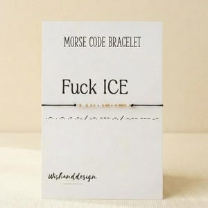 May include: A Morse code bracelet on a white card. The card reads "MORSE CODE BRACELET" at the top, with "Fuck ICE" in large letters below. The bracelet is black with gold beads. The card also has the text "Wishanddesign" at the bottom.