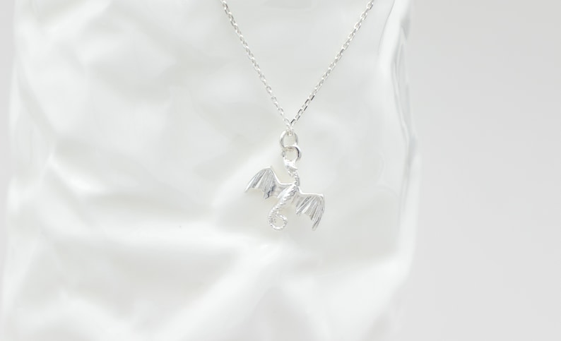 handcrafted sterling silver necklace with small flying dragon pendant on adjustable chain