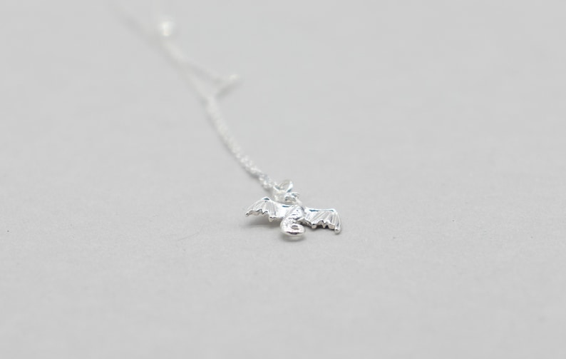handcrafted sterling silver necklace with small flying dragon pendant on adjustable chain
