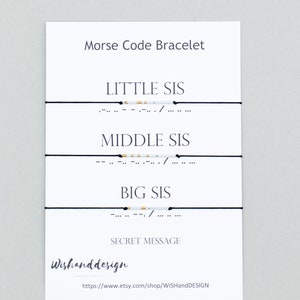 Puede incluir: Tres pulseras de cuerda negra con cuentas blancas y doradas que deletrean "Little Sis", "Middle Sis" y "Big Sis" en código Morse. Las pulseras se muestran en una tarjeta blanca con el texto "Pulsera de código Morse" y "Mensaje secreto".