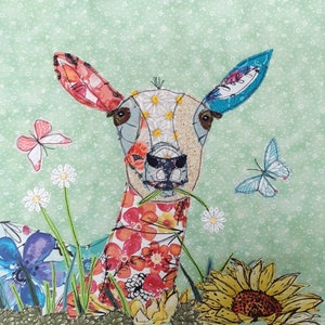 May include: A colorful, whimsical art piece depicting a deer with a floral patterned body, surrounded by flowers and butterflies. The deer's head is made of fabric and has a textured, realistic look. The background is a light green with a subtle pattern.