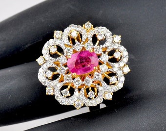 May include: A gold ring with a pink oval gemstone surrounded by smaller white gemstones in a floral design.