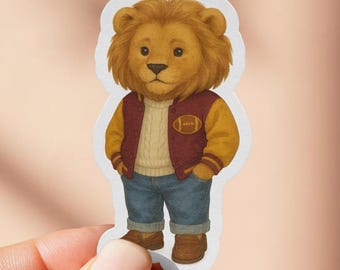 May include: A sticker featuring a cartoon lion wearing a maroon and gold letterman jacket, a cream-colored sweater, blue jeans, and brown boots. The lion has a golden mane and a friendly expression. The sticker is held by a hand against a pink background.