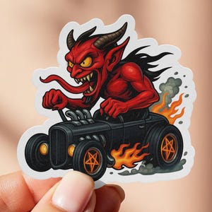 Puede incluir: Una pegatina con un diablo rojo con cuernos y una larga lengua conduciendo un hot rod negro. El coche tiene llamas naranjas y llantas en forma de estrella. El diablo tiene una expresión enfadada.