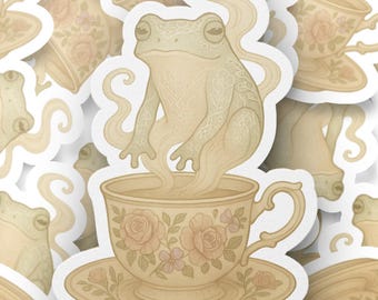 Könnte beinhalten: Eine Sammlung von Aufklebern mit einem Frosch in einer Teetasse. Die Teetasse und Untertasse sind mit floralen Mustern verziert. Der Frosch ist hellgrün und die Teetasse ist beige.