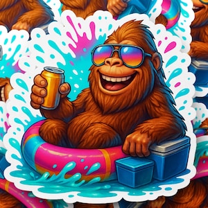May include: A cartoon sticker featuring a smiling Bigfoot wearing sunglasses and floating in a colorful inflatable ring. The Bigfoot holds a can of soda and is surrounded by water splashes and a cooler.